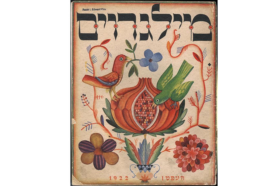 A Yiddish journal cover with Hebrew writing at the top and an illustration of a red bird surrounded by flowers