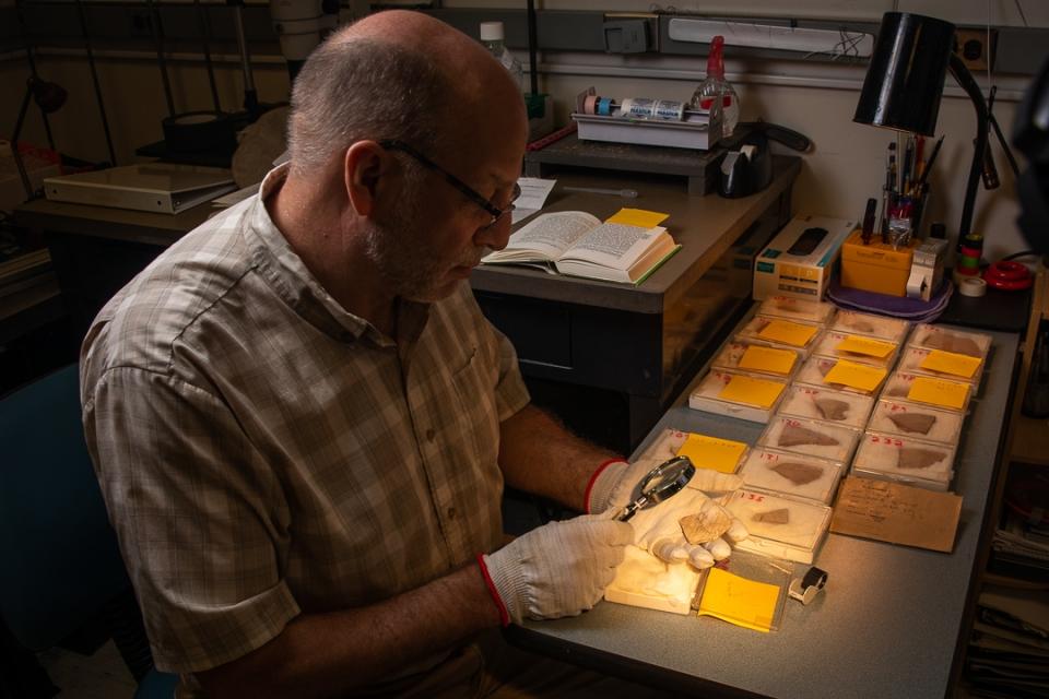 Christopher Rollston examines a dead sea scroll segment 