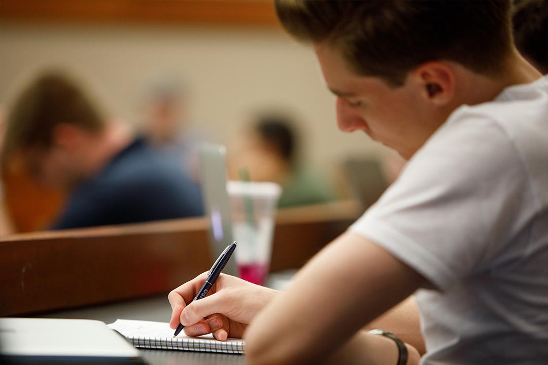 A student writing on a notepad